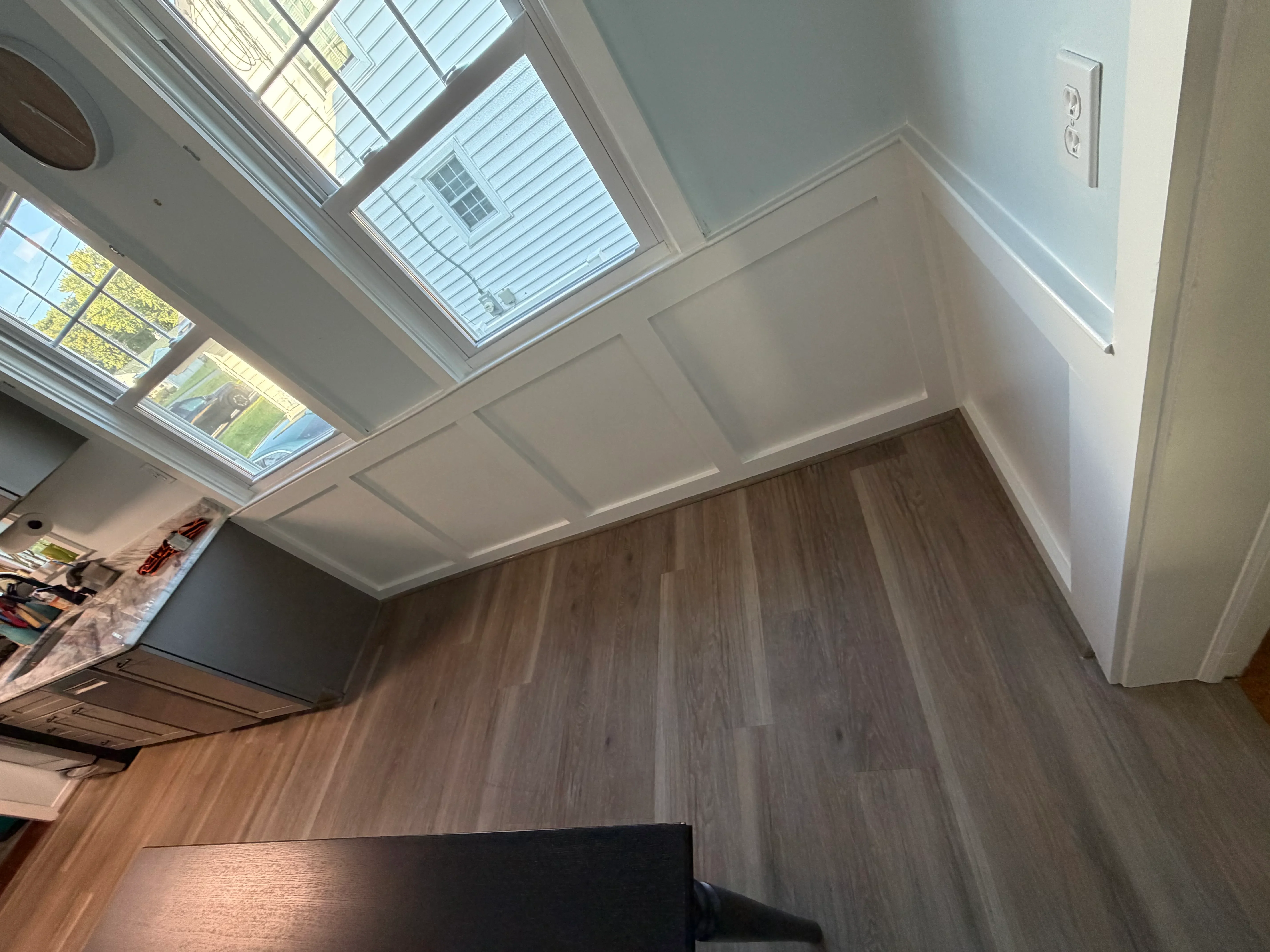 Multiple skylights installed in white coffered ceiling with wood flooring below